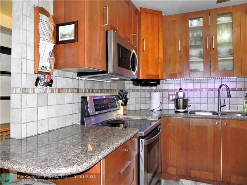 4350 Hillcrest Drive, Unit 212 Hollywood, FL 33021 - Photo 5 of 38 a kitchen with stainless steel appliances granite countertop a sink a microwave counter space and a window