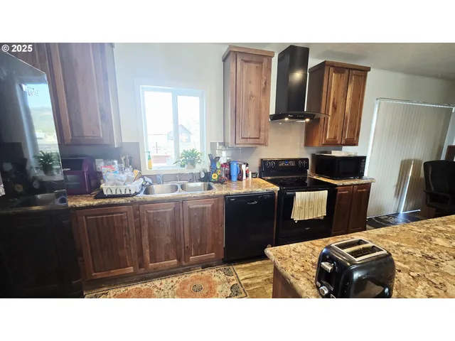 a kitchen with a sink wooden cabinets and a refrigerator