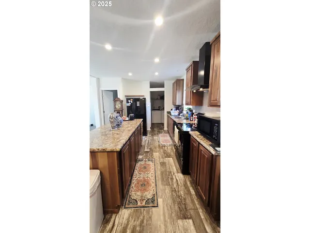 a living room with stainless steel appliances kitchen island granite countertop furniture and a kitchen view