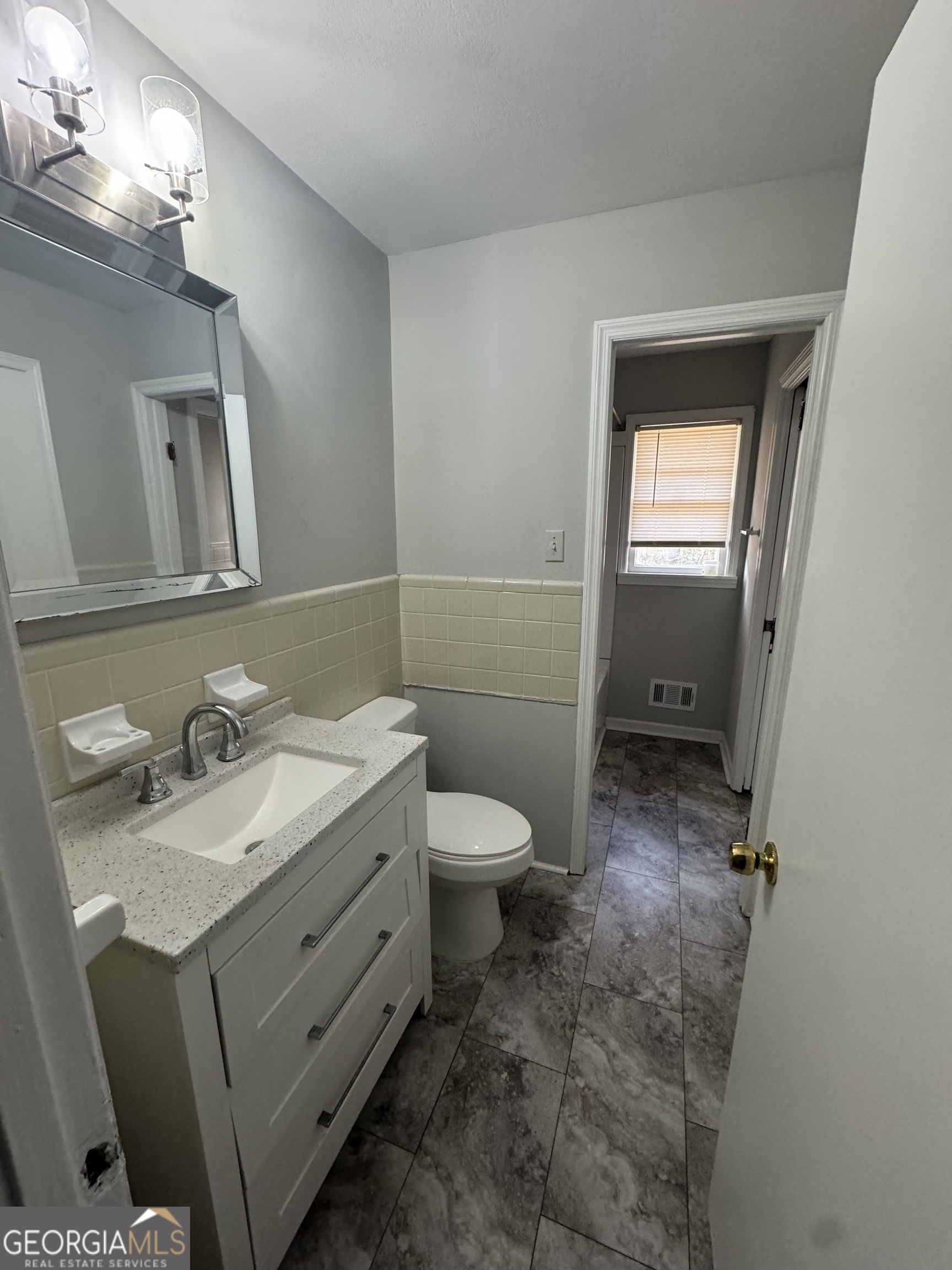4367 Pharr Avenue Macon, GA 31210 - Photo 8 of 12 a bathroom with a granite countertop toilet sink and mirror