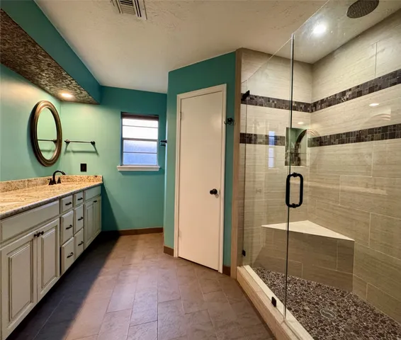 a bathroom with a double vanity sink mirror and shower