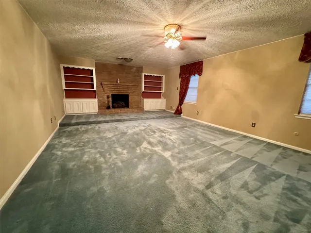 a view of empty room with fireplace and fan