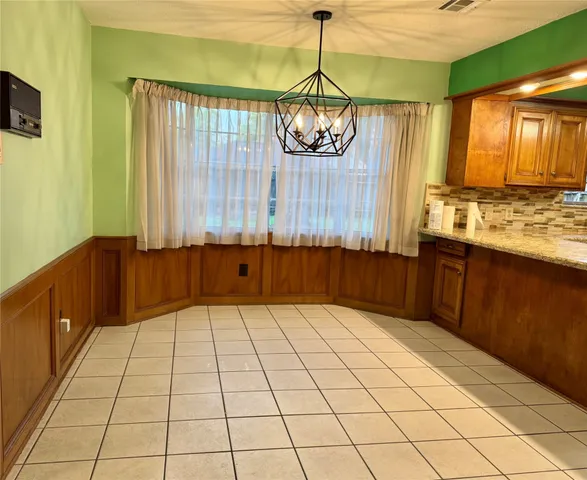 a view of kitchen with granite countertop cabinets and window