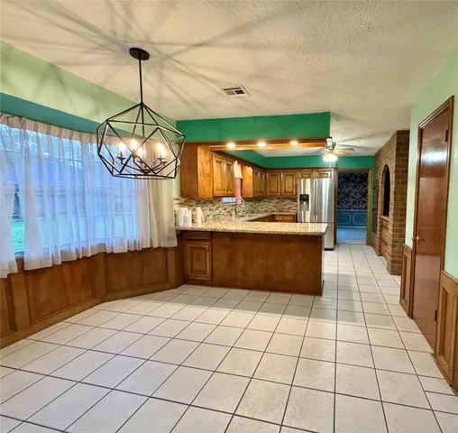 a kitchen with stainless steel appliances a sink a counter top space cabinets and a window
