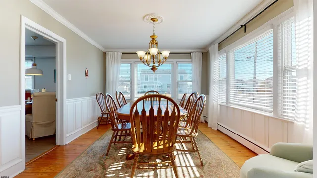 a dining room with furniture a chandelier and wooden floor