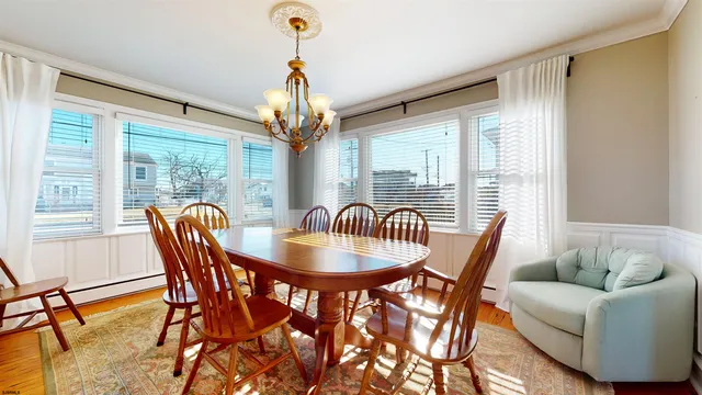 a dining room with furniture a chandelier and wooden floor