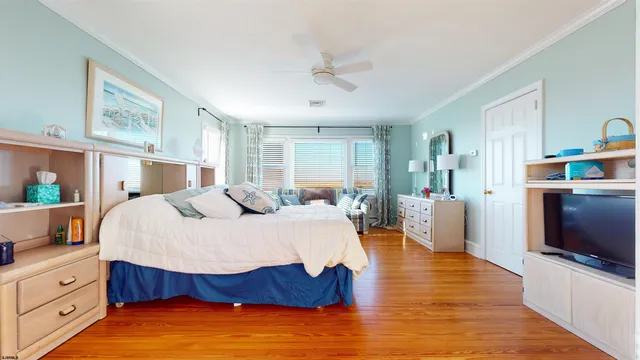 a spacious bedroom with a bed and a flat screen tv
