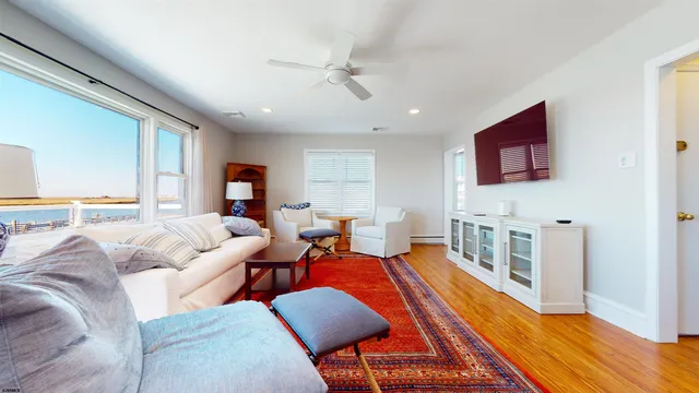 a living room with furniture kitchen view and a large window