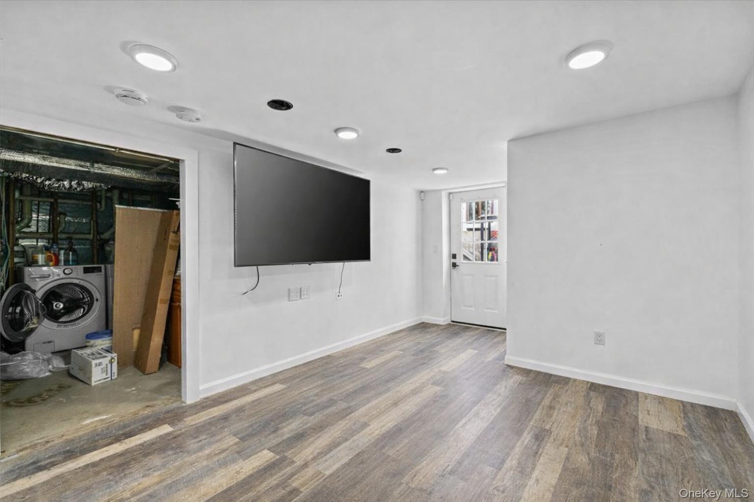 85 Joline Road Port Jefferson Station, NY 11776 - Photo 22 of 30 a view of a livingroom with a flat screen tv wooden floor and windows