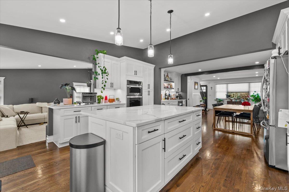 85 Joline Road Port Jefferson Station, NY 11776 - Photo 10 of 30 a kitchen with white cabinets and chairs