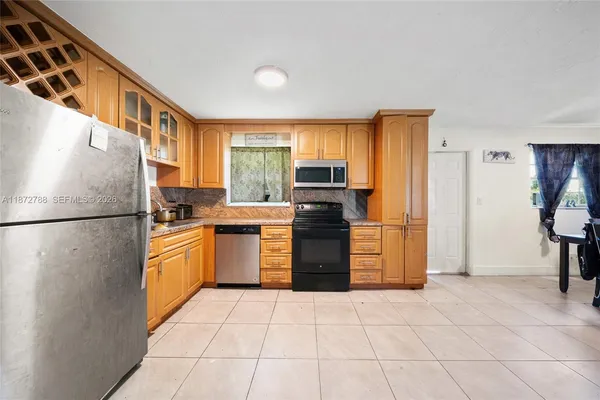 a kitchen with a refrigerator a stove top oven and a refrigerator