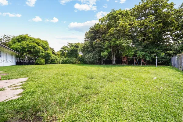 a view of green field with trees in the background