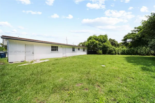 a backyard of a house with lots of green space and plants