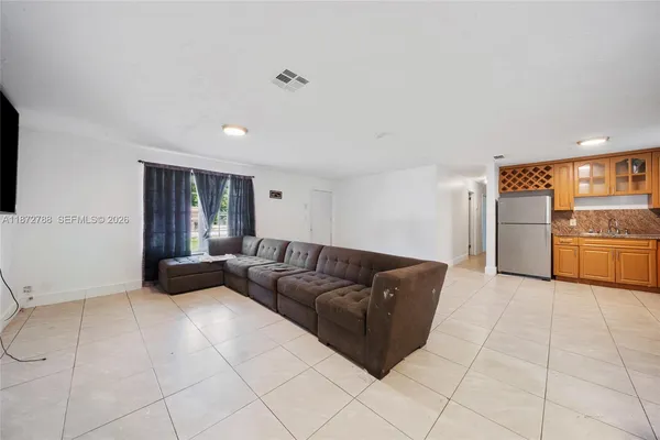 a living room with furniture and kitchen view