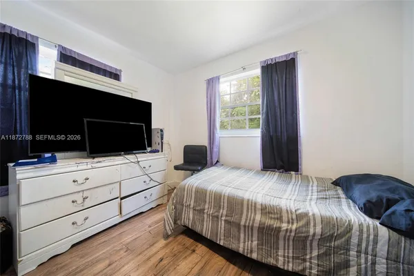 a bedroom with a bed and flat screen tv