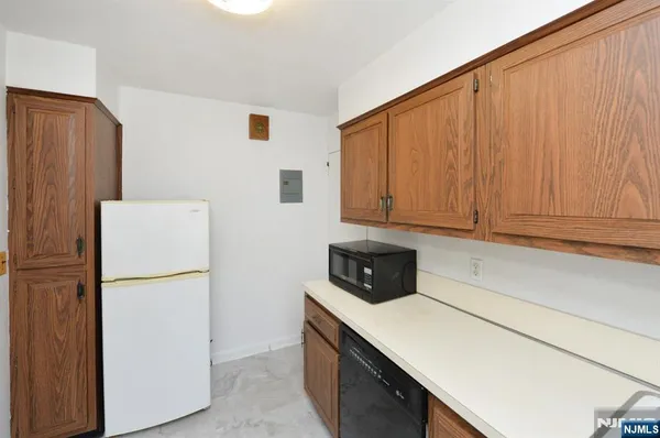 a kitchen with a white cabinets and a refrigerator