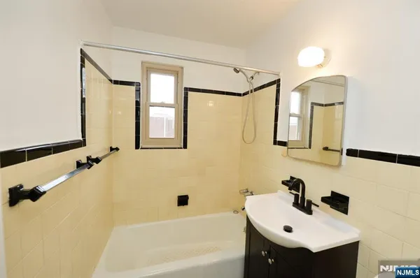 a bathroom with a bathtub sink and mirror