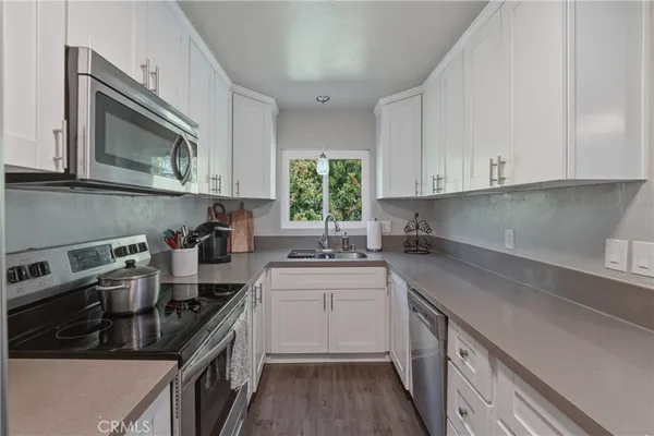 a kitchen with a sink stove top oven and cabinets