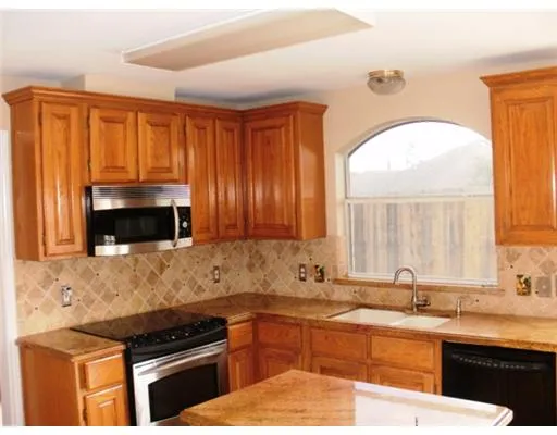 a kitchen with a sink and a stove top oven