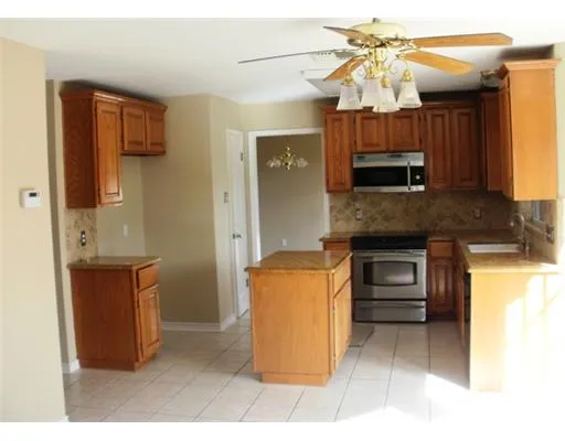a kitchen with stainless steel appliances granite countertop a sink and a refrigerator