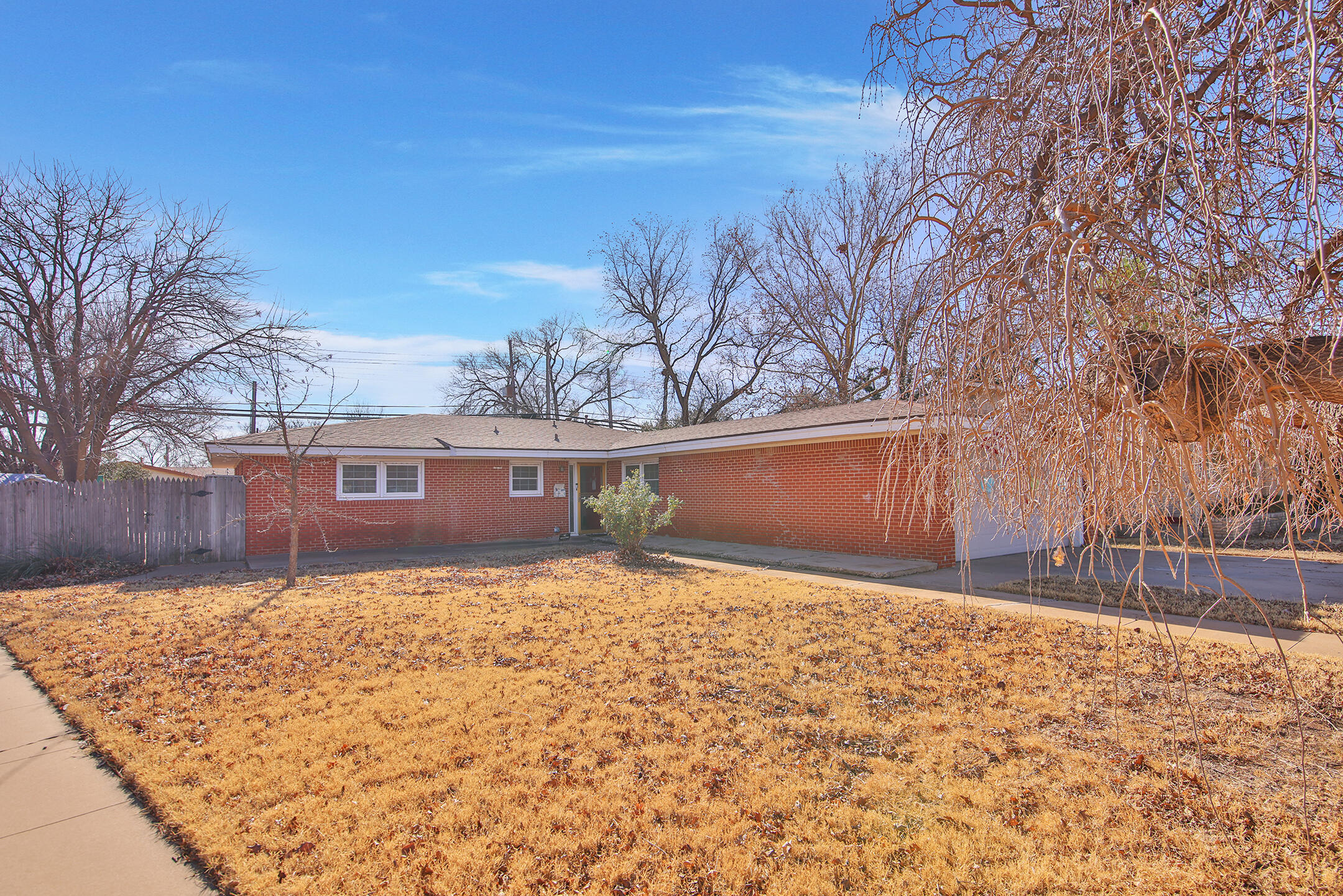 a front view of a house with a yard covered with snow