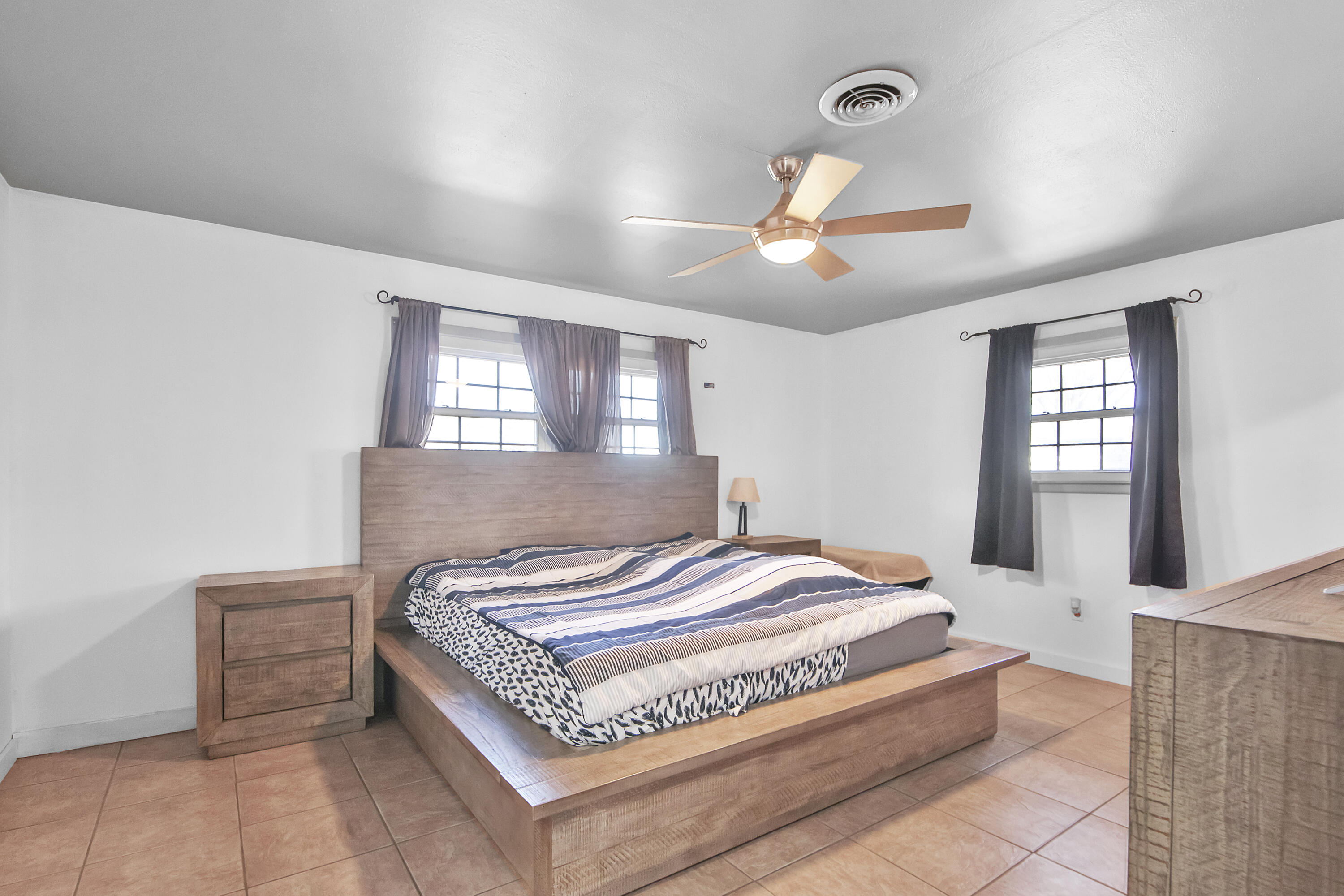 2801 52nd Street Lubbock, TX 79413 - Photo 21 of 34 a spacious bedroom with a bed and a chandelier