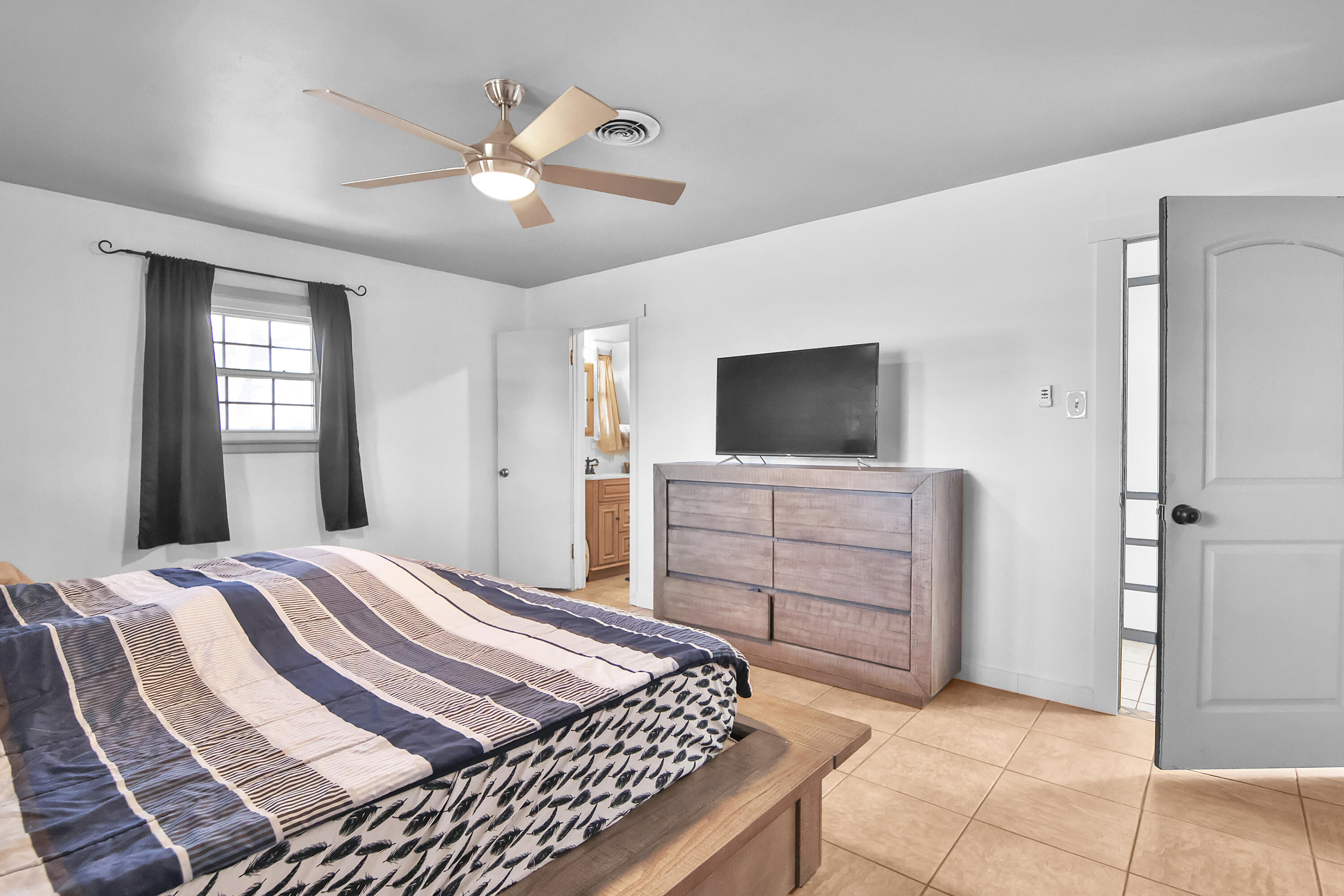 2801 52nd Street Lubbock, TX 79413 - Photo 22 of 34 a bedroom with a bed and a flat screen tv