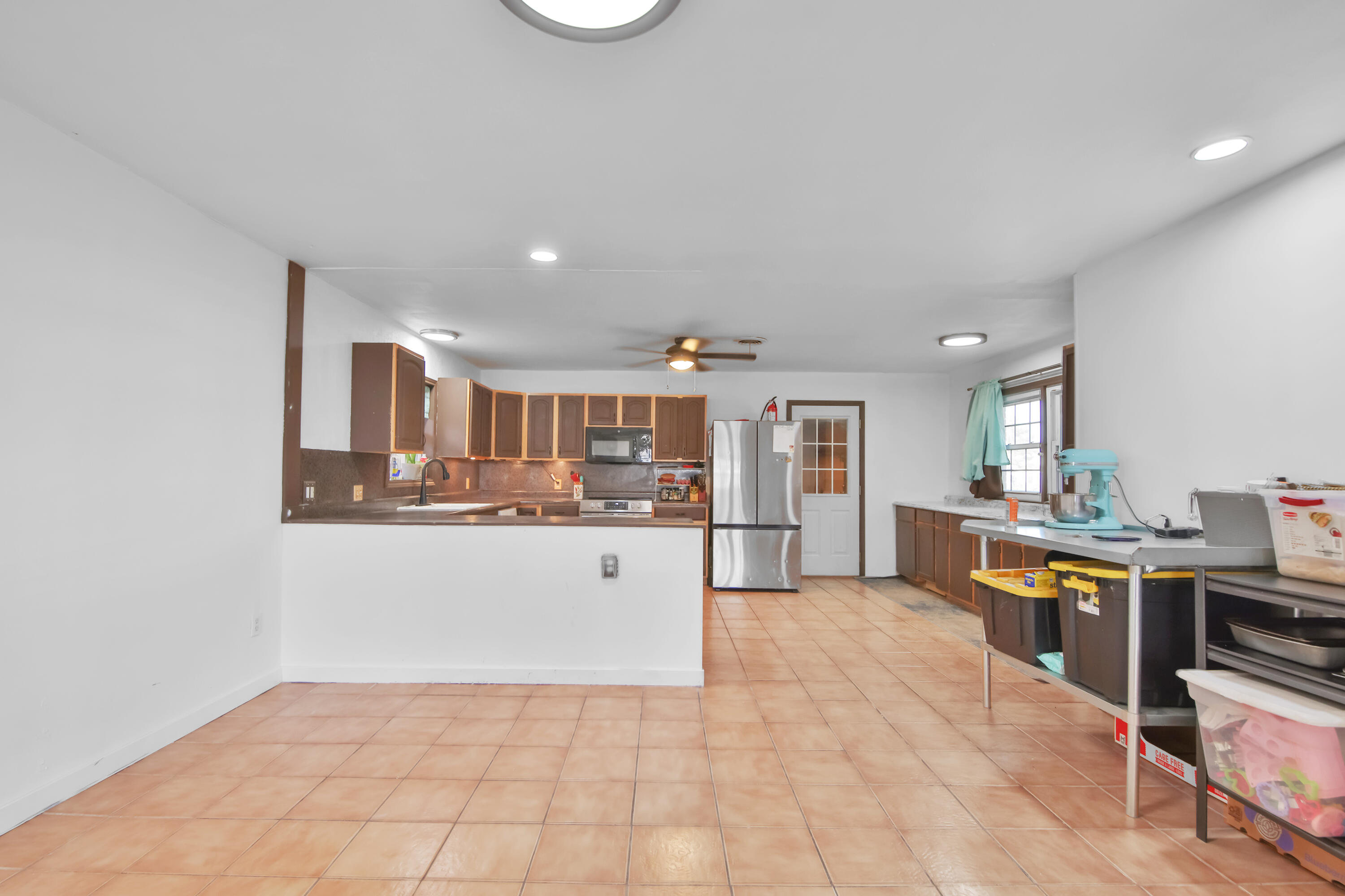 2801 52nd Street Lubbock, TX 79413 - Photo 7 of 34 a living room with stainless steel appliances kitchen island granite countertop a refrigerator a stove a sink dishwasher and white cabinets with wooden floor