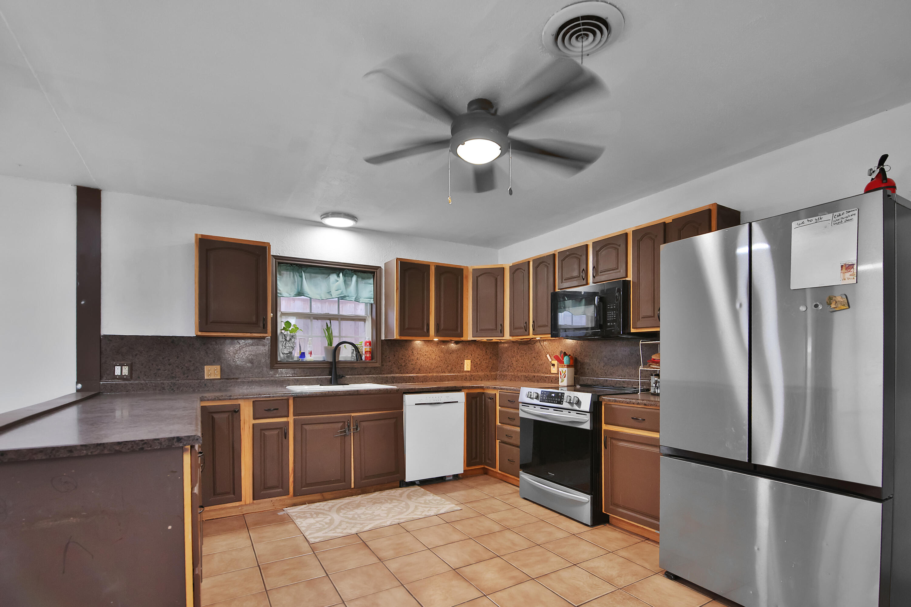 2801 52nd Street Lubbock, TX 79413 - Photo 9 of 34 a kitchen with stainless steel appliances granite countertop a refrigerator sink and cabinets