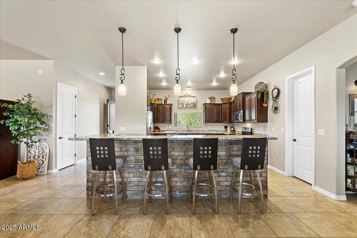 2135 West Bridle Path Road Prescott, AZ 86305 - Photo 9 of 32 a kitchen with stainless steel appliances a dining table chairs and white cabinets