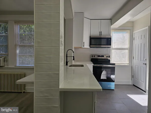 a kitchen with a sink a stove and cabinets