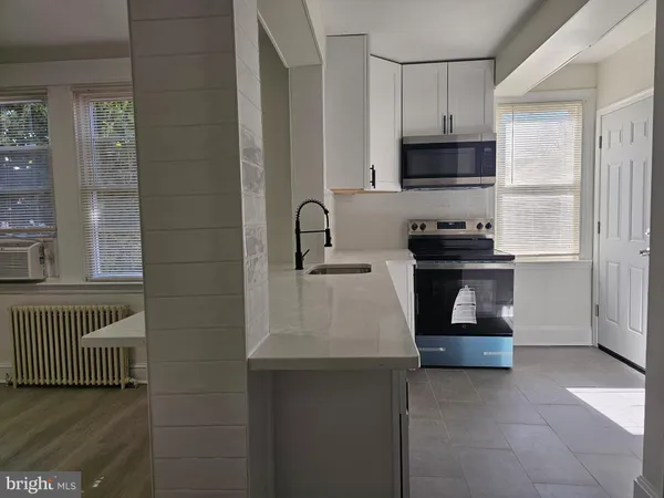 a kitchen with stainless steel appliances a sink stove and cabinets