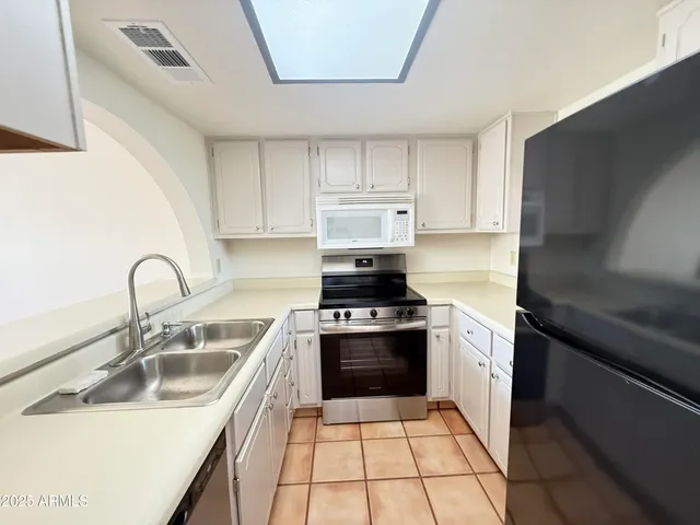 a kitchen with a sink stove top oven and refrigerator