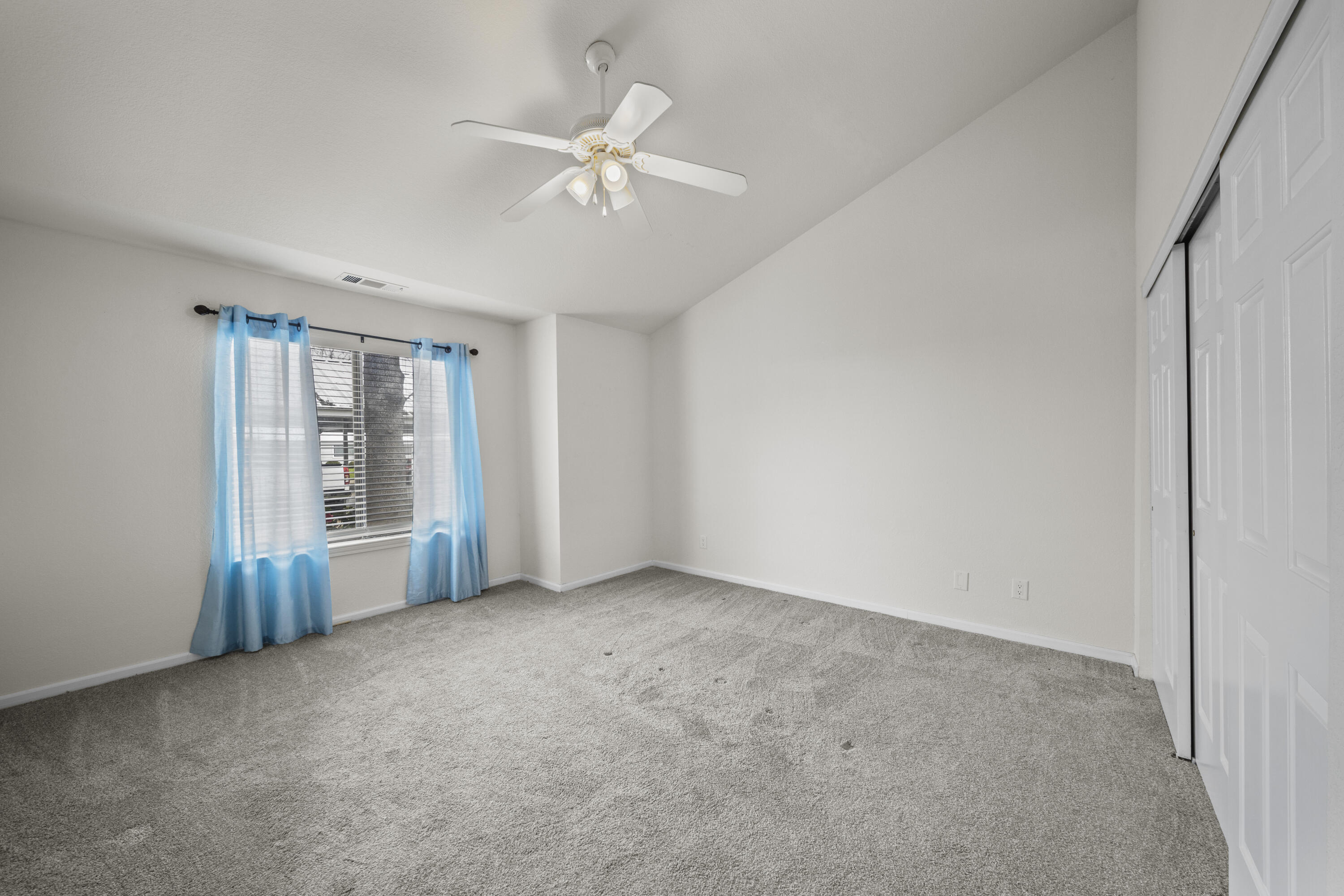 6014 Mid Drive Trail Redding, CA 96003 - Photo 7 of 15 an empty room with chandelier fan and windows