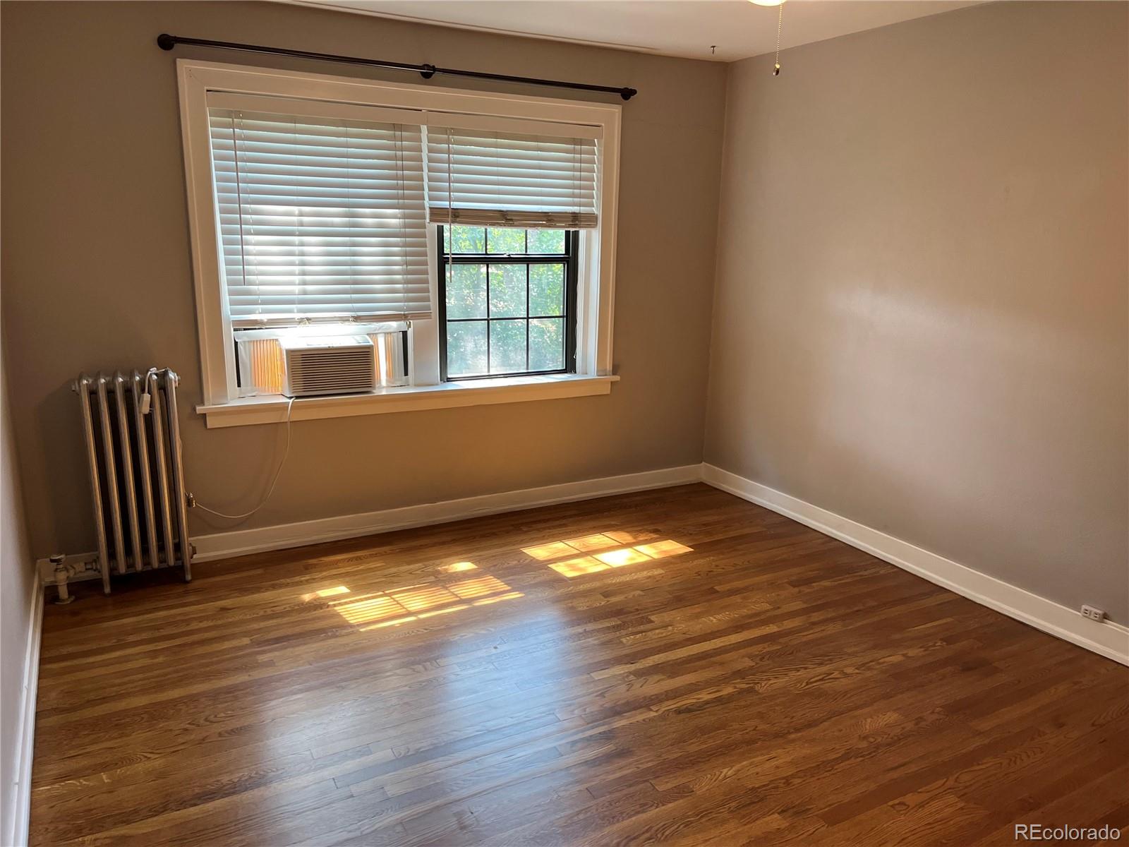 1684 Harrison Street, Unit 8 Denver, CO 80206 - Photo 15 of 21 a view of empty room with wooden floor and fan