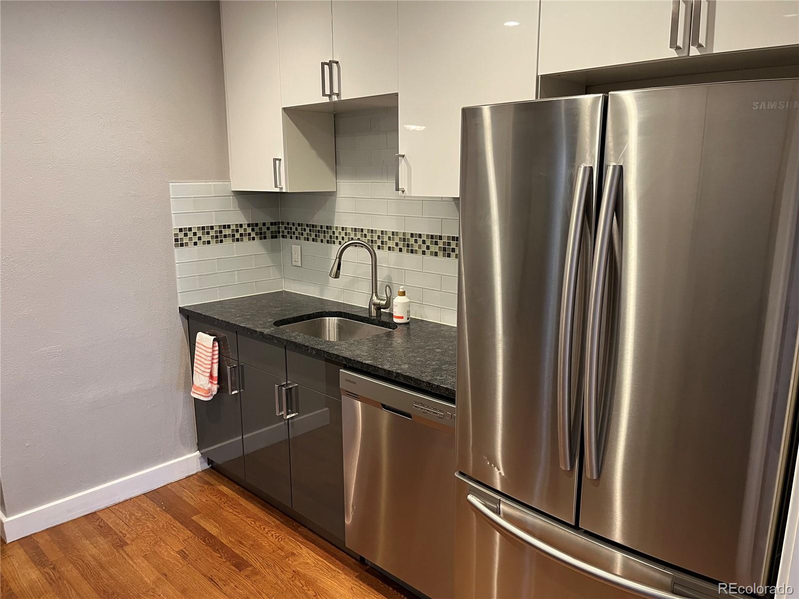 1684 Harrison Street, Unit 8 Denver, CO 80206 - Photo 7 of 21 a kitchen with stainless steel appliances granite countertop a refrigerator and a sink