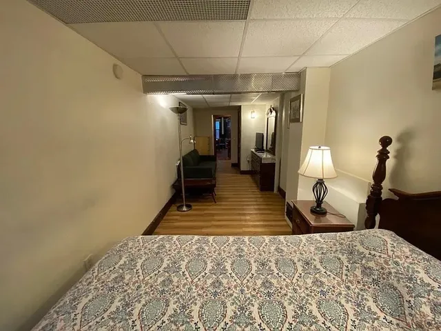 a bedroom with a bed a mirror and lamp on desk