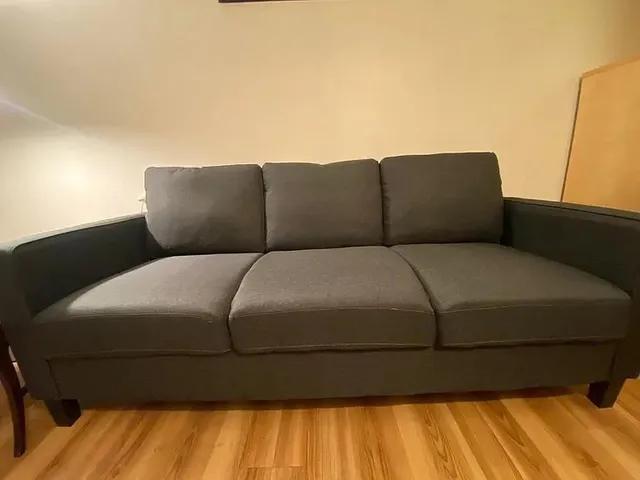 a blue bed sitting in a bedroom next to a larger window