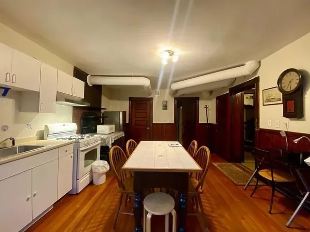 a kitchen with a dining table chairs and white cabinets
