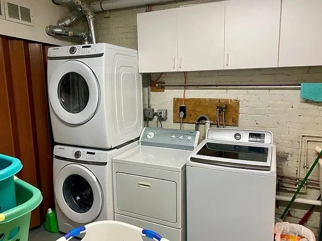 a utility room with dryer washer and wooden floor