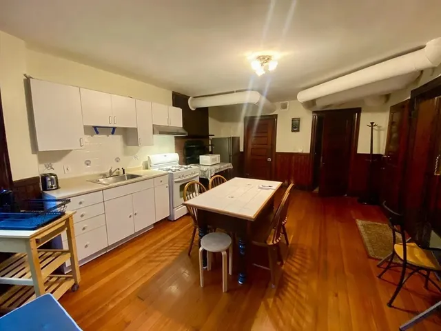 a kitchen with a table chairs refrigerator and cabinets