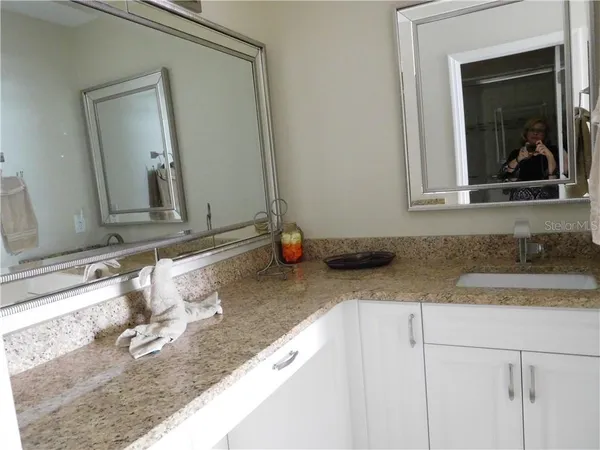 a bathroom with a granite countertop sink and a mirror