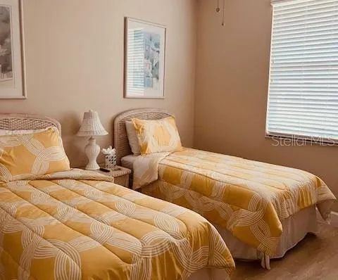 a bedroom with two beds and painting on the wall