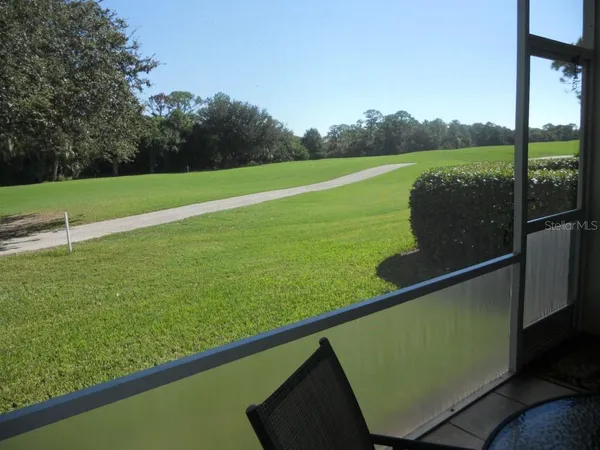 a view of a green field with sitting area