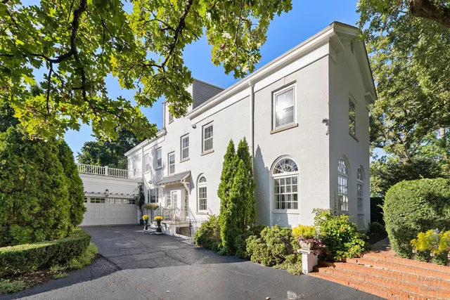 a front view of a house with a yard and fountain in middle