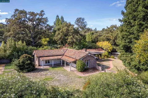 an aerial view of a house with a yard and sitting area