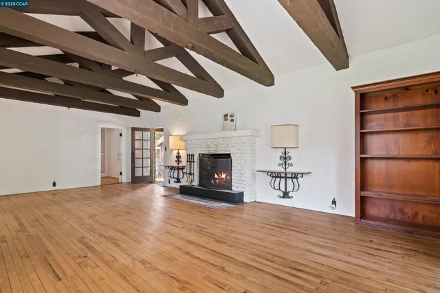a view of empty room with wooden floor and fireplace