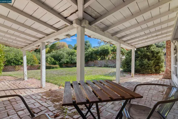 a view of a patio with a table chairs and a backyard