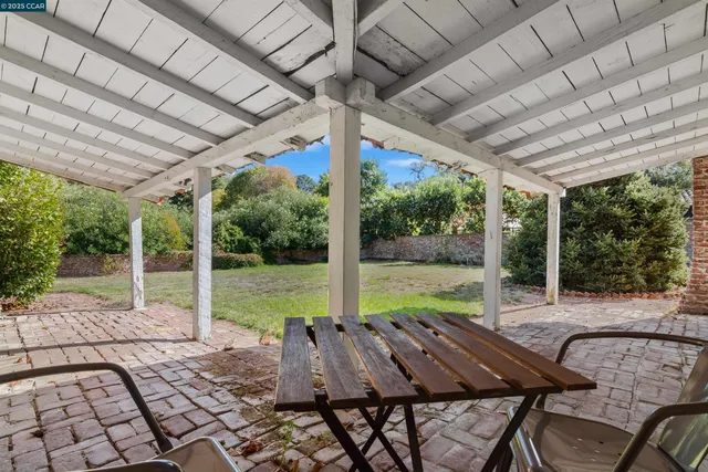 a view of a patio with table and chairs next to a yard
