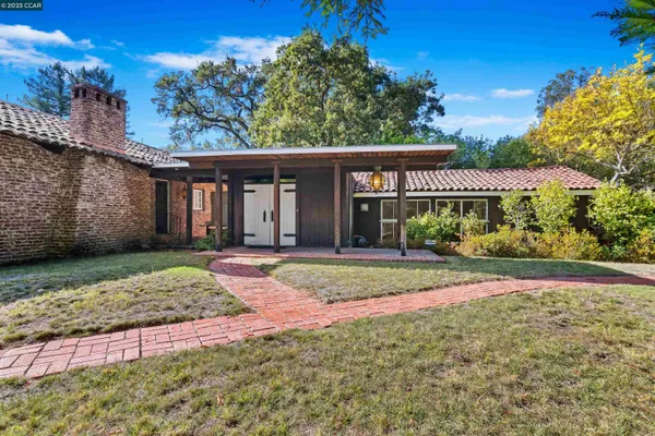 a view of a house with a yard and tree s